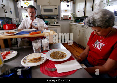 Dec 07, 2005; West Palm Beach, FL, USA; Don Chester and his wife Sally Chester say a prayer before eating lunch at their home in West Palm Beach. Don and Sally believe prayers from friends and family has helped them cope with Don being paralyzed. Don was paralyzed when struck by a car December 24, 2004 while jogging. Mandatory Credit: Photo by Gary Coronado/Palm Beach Post /ZUMA Pr Stock Photo