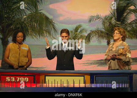 Dec 10, 2005; Ft. Lauderdale, FL, USA; Wheel of Fortune contestant Thomas Dunn III, center, throws up his hands at a bad spin as he tapes one of the show's 'Fun In The Sun' segments at the Broward County Convention Center in Ft. Lauderdale Saturday, Dec. 10, 2005. Dunn is a Palm Beach Atlantic College junior. Competing against Dunn are Silianise Donjoie of Miami, left, and Mayra Mi Stock Photo