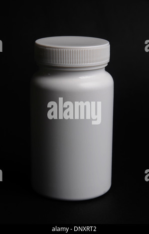 White bottle for capsules on black. Stock Photo