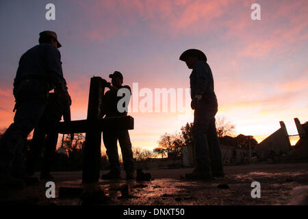 Dec 28, 2005; Cross Plains, TX, USA; Curtis Cooper, from left, Tony Wyatt, and Tim Byrley hold the cross that once stood atop First United Methodist Church of Cross Plains after a devastating grass fire in Cross Plains, TX on Wednesday, December 28, 2005. The men cut off part of the most burnt part of the cross with a saw.  Mandatory Credit: Photo by L. Krantz/San Antonio Express-N