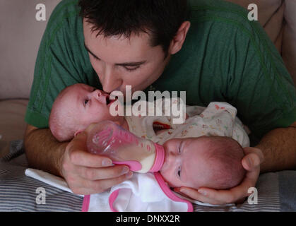 Jan 07, 2006; Fargo, ND, USA; (Left to right) Isabelle gets a kiss from her dad, Jesse Carlsen, as Abbigail  gets a bottle.  The conjoined twins were at home in Fargo, N.D. with their parents, Amy and Jesse Carlsen. They will be separated when they grow a little bigger and stronger--they are about a month old in this photo. Mandatory Credit: Photo by Joey McLeister/Minneapolis Star Stock Photo