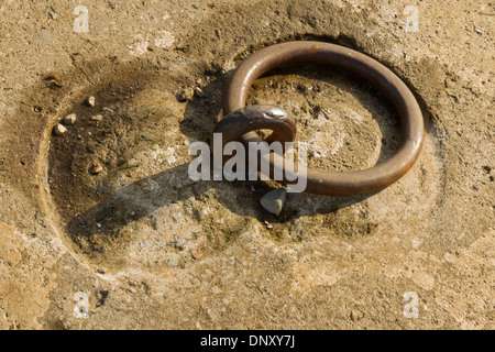 Iron mooring ring set in concrete. Closeup. Stock Photo