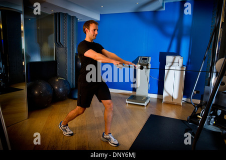 Gary Hicking, personal trainer in London, UK, keeping fit with core upper body training using weights and pully system Stock Photo