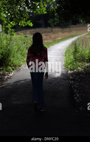 Young girl walking along a path. Back to camera. Stock Photo