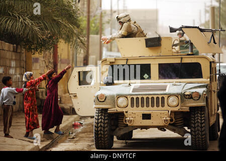 Feb 08, 2006; Al-Falujah, IRAQ; A marine from Weapons company 2nd marine division, 2nd battalion, 6th marine regiment, RCT-8, 4th platoon (callsign Black Label) tosses candy to children during a patrol of the Iraqi city of Al-Falujah. Mandatory Credit: Photo by Toby Morris/ZUMA Press. (©) Copyright 2006 by Toby Morris Stock Photo