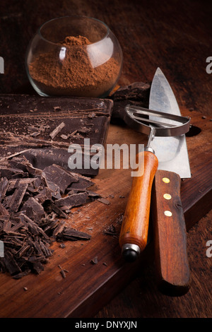 Cut Chocolate bars and cocoa powder on a wooden table Stock Photo
