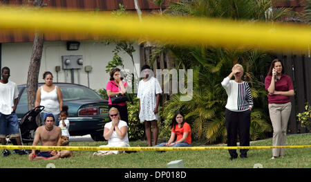 Feb 23, 2006; Greenacres, FL, USA; From across the pond, neighbors watch while investigators examine the site where the body of  8-year-old  Jared McGuire, who had been missing since Thursday afternoon, was found.  The boy  was found  Friday morning in a  pond about a hundred yards from his home in The Pines  development. He was found by Palm Beach Sheriff's Deputy Ray Griffith, wh Stock Photo