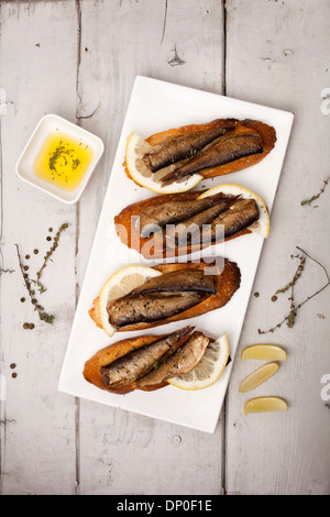 Fish, Spanish tapas - sprat with lemon on baked bread Stock Photo