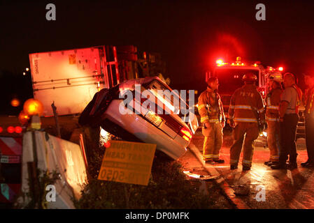 Mar 27, 2006; Palm Beach, FL, USA; Firefighters stand next to a white Saturn Sedan where an elderly couple died after being hit by an 18 wheeler at the intersection of Southern Blvd and Sansbury Way. Witnesses said the 18 wheeler ran the red light as it traveled east on Southern Blvd. The car was headed north on Sansbury Way when it was hit and pushed onto a concrete barrier. The t Stock Photo