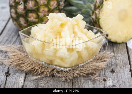 Canned Pineapple on vintage wooden background (close-up shot) Stock Photo