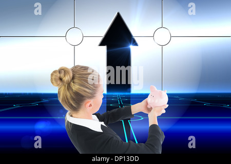 Composite image of businesswoman holding pink piggy bank Stock Photo