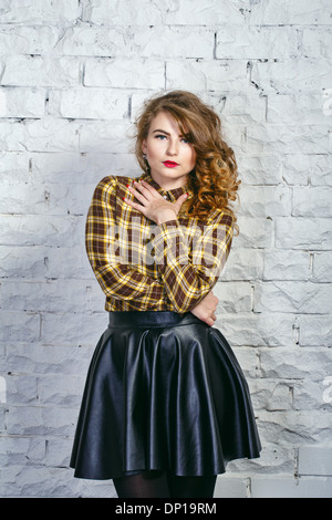 Attractive young girl in plaid shirt and leather skirt Stock Photo