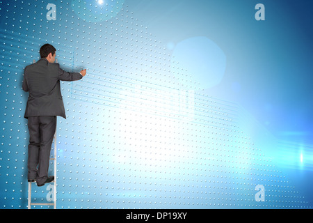 Composite image of businessman standing on ladder Stock Photo
