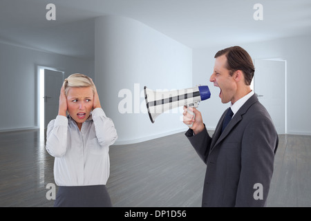 Composite image of businessman shouting at colleague with his bullhorn Stock Photo