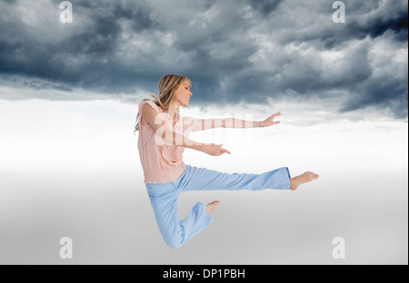 Composite image of woman doing dance pose Stock Photo
