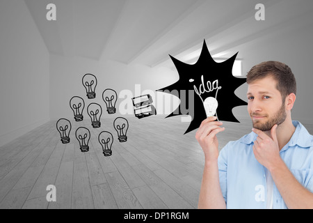 Composite image of handsome model holding a bulb Stock Photo