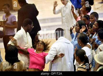 May 07, 2006; Delray Beach, FL, USA; A man helps a priest drag a woman from the aisle who collapsed after 'catching the Spirit' during Mass as Charismatic Christians worshipped  at  Delray Beach's Our Lady of Perpetual Hope on Sunday for their statewide convention.  Mandatory Credit: Photo by Lannis Waters/Palm Beach Post/ZUMA Press. (©) Copyright 2006 by Palm Beach Post Stock Photo