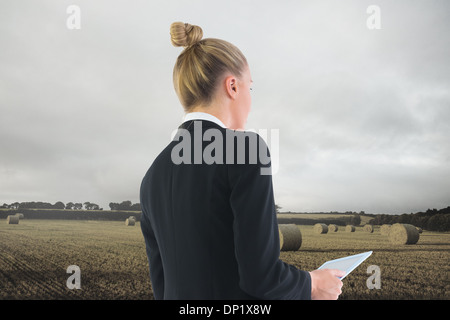 Composite image of businesswoman holding tablet Stock Photo