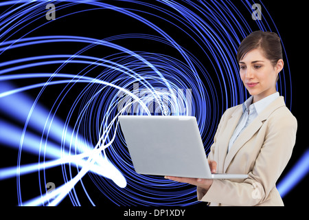 Composite image of confident businesswoman holding laptop Stock Photo