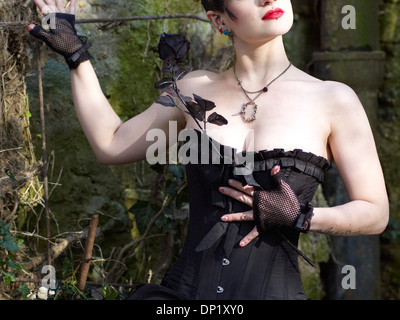 Woman with corset holding a black rose, Germany Stock Photo