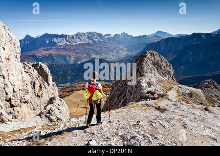 Mountain climber descending from Peitlerkofel Mountain in Puez-Geisler Nature Park, overlooking Val Badia valley, Stock Photo