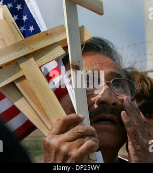 May 17, 2006; Imperial Beach, CA, USA; At the Imperial Beach Border Patrol Station, the Congressional Subcommittee on International Terrorism and Nonproliferation holds the first in a series of congressional hearings on immigration.  MOISES TORRES of Los Angeles holds the U.S. flag along with several wooden crosses.  The wooden cross were symbolic of the more than 4-thousand deaths Stock Photo