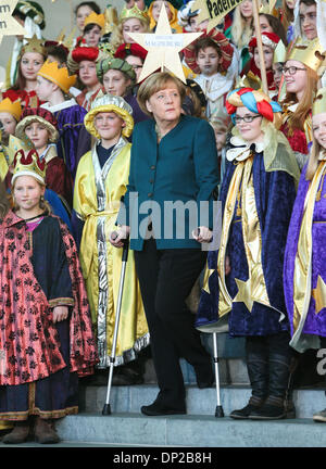 Berlin, Germany. 7th Jan, 2014. German Chancellor Angela Merkel (C) stands with crutches as she attends a reception with young carol singers at the Chancellery in Berlin, capital of Germany, on Jan. 7, 2014. German Chancellor Angela Merkel has injured her pelvis in a cross-country skiing accident in Switzerland and will have to cancel several meetings, her spokesman Steffen Seibert said on Monday. Credit:  Zhang Fan/Xinhua/Alamy Live News Stock Photo