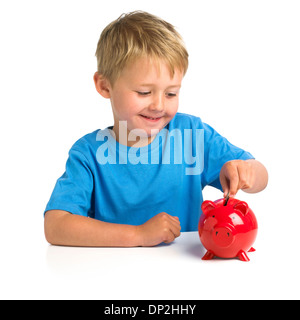 Boy putting money in a piggy bank Stock Photo