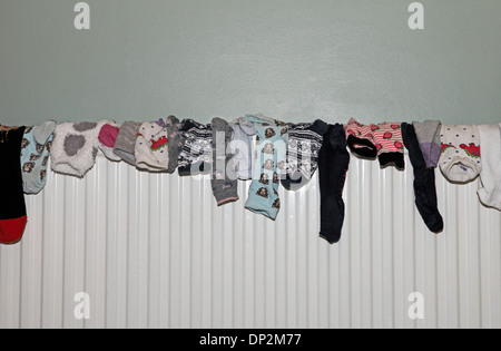 collection of socks drying on a radiator Stock Photo