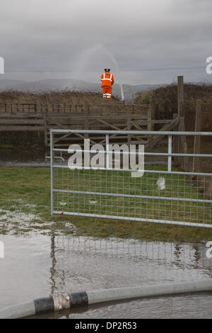 Y Borth, Ceredigion, Wales, UK. 7th January 2014. Following several days of vicious gales and very high tides, emergency services, council and Network Rail staff are working flat out to clear-up and safeguard essential services and protect residents. Aberystwyth (Mid and West Wales) fire service led by Fire Incident Commander, Alan Jones, attended Cae Gwylan in the costal village of Borth 3 times during the day to pump sea flood water away from houses and an electricity sub-station at the storm-battered village of Borth. Credit:  atgof.co/Alamy Live News Stock Photo