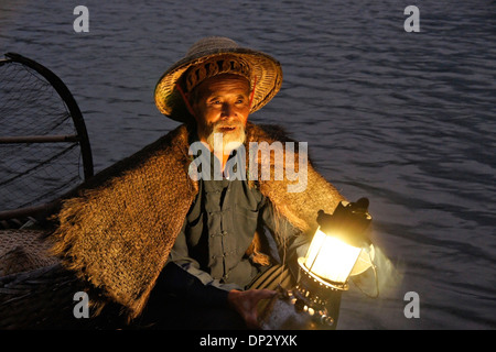 Cormorant fisherman lighting lantern, Li River (Lijiang), Xingping, Guangxi, China Stock Photo
