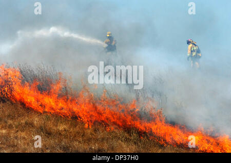 Jun 23, 2006; Antioch, CA, USA; Firefighters tackle a grass fire in Contra Costa County near Antioch, Calif. Friday, June 23, 2006. 22 acres were charred in the blaze that was battled on the ground by crews from the California Department of Forestry, East Contra Costa Fire, Contra Costa Fire and from the air by airplanes and a helicopter from CDF and a helicopter from East Bay Park Stock Photo