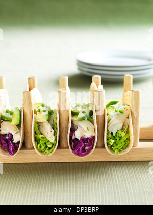 Fish Tacos with Red Cabbage and Green Cabbage in Soft Taco Shells, topped with Sour Cream, Avocado and Jalapeno Stock Photo