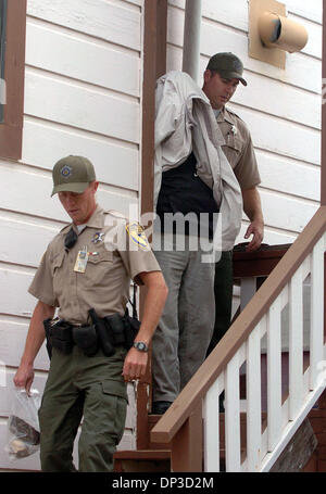 Jun 29, 2006; San Francisco, CA, USA; As California Department of Fish and Game warden Bob Pera (left) carries out evidence, warden Clint Garrett (right) leads out Bao Zhang as he was arrested at his South San Francisco home on Thursday, June 29, 2006. Zhang was arrested on 3 counts of buying and selling abalone illegally. Zhang is the owner of Bob's Sushi restaurant in San Francis