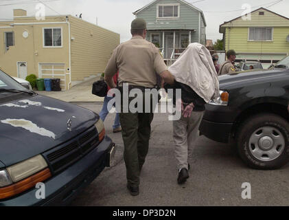 Jun 29, 2006; San Francisco, CA, USA; California Department of Fish and Game warden Clint Garrett leads Bao Zhang to an awaiting vehicle as he was arrested at his South San Francisco home on Thursday, June 29, 2006. Zhang was arrested on 3 counts of buying and selling abalone illegally. Zhang is the owner of Bob's Sushi restaurant in San Francisco.   Mandatory Credit: Photo by Dan 