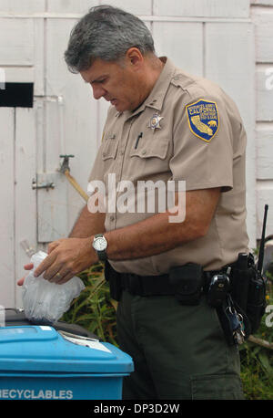 Jun 29, 2006; San Francisco, CA, USA; California Department of Fish and Game Capt. Dave Fox looks for discarded abalone in some trash as Bao Zhang, owner of Bob's Sushi House, was arrested at his San Francisco, Calif. home on Thursday, June 29, 2006. Zhang was arrested on 3 counts of illegally buying and selling abalone.  Mandatory Credit: Photo by Dan Honda/Contra Costa Times/ZUMA