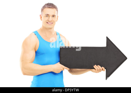 Male athlete holding a big black arrow pointing right Stock Photo