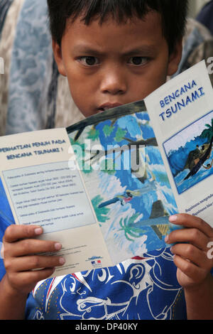 Jul 20, 2006; Ciamis, West Java, INDONESIA; A child in the refugee center reads a brochure about tsunamis. The brochures were donated by Gadjah Mada University Earthquake and Tsunami Research Center in Yogyakarta. The villagers who survived the tsunami still worry about the possibilities of another earthquake and tsunami. A tsunami hit the coast of the Indonesian island of Java kil Stock Photo