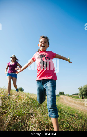 Girls running in field, Germany Stock Photo