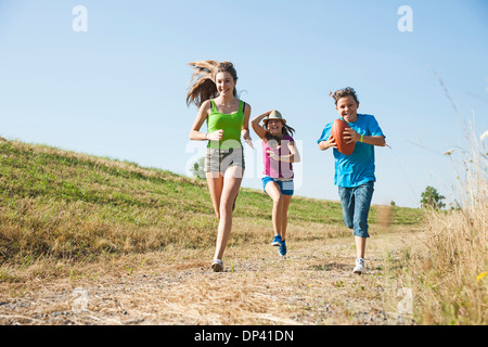 Girls running along pathway in field, Germany