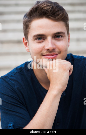 Close-up portrait of young man outdoors, smiling at camera, Germany Stock Photo