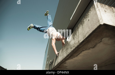 Teenaged boy doing handstand on cement road, freerunning, Germany Stock ...