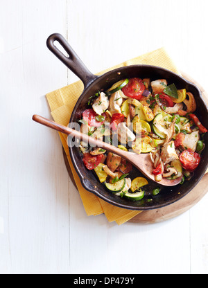 Overhead View of Chicken and Mushroom Ratatouille in Cast Iron Skillet with Wooden Spoon, Studio Shot Stock Photo