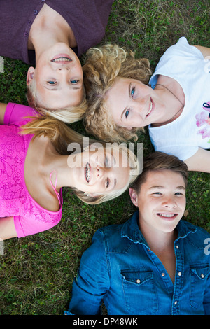 Overhead View of Teenagers Lying on Grass, Mannheim, Baden-Wurttemberg, Germany Stock Photo
