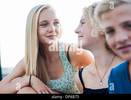 Close-up portrait of teenage girls and boy sitting outdoors, Germany Stock Photo