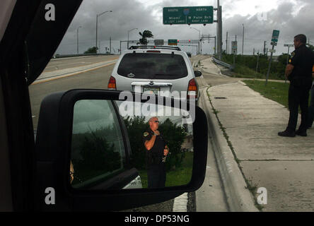 Aug 30, 2006; Boynton Beach, FL, USA; Boynton Beach Police officer Rich McNevin (cq) is reflected in a sideview mirror as he assists Sgt. Steve Wessendorf (cq), not pictured, and Sgt Sewart Steele (cq), right, with a traffic stop on Gateway Blvd. Wednesday morning, Aug. 30, 2006. The Department expected much more activity, the worst of which would come from Tropical Storm Ernesto.  Stock Photo