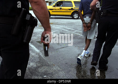 Aug 30, 2006; Boynton Beach, FL, USA; Boynton Beach Police Officer Rich McNevin (cq), right, takes a suspected habitual bad driver back to the station as Sgt. Stewart Steele (cq) carries his stun gun through the parking lot of a coin laundry Wednesday morning, Aug. 30, 2006. The Department expected much more activity, the worst of which would come from Tropical Storm Ernesto. The d Stock Photo