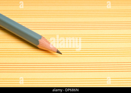 pencil on a yellow paper with lines Stock Photo