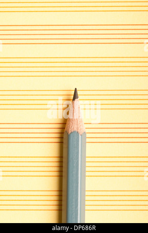 pencil on a yellow paper with lines Stock Photo