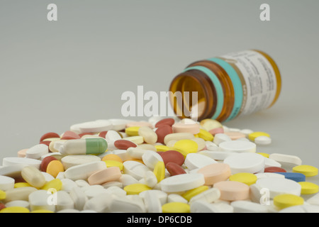 many colored drugs pills shapes outside a bottle Stock Photo